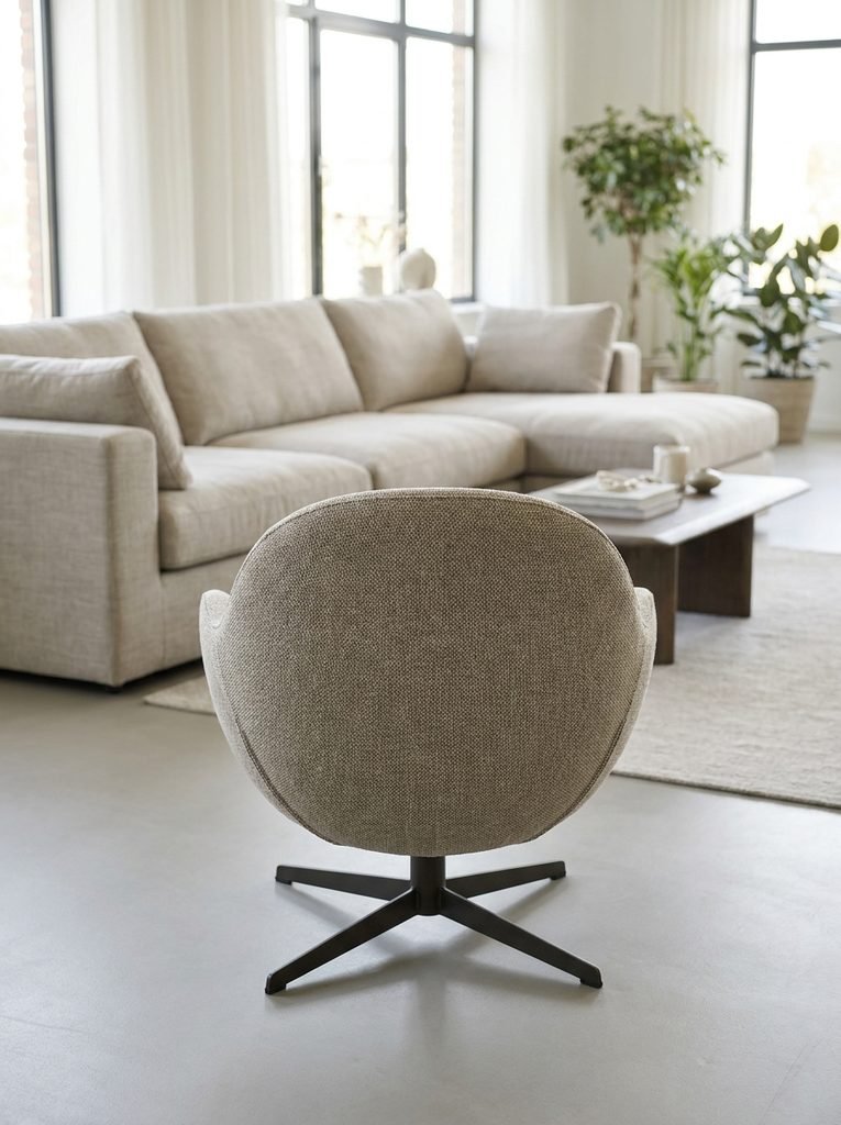 Back view of a curved swivel accent chair floating in an open-plan living room facing a sofa